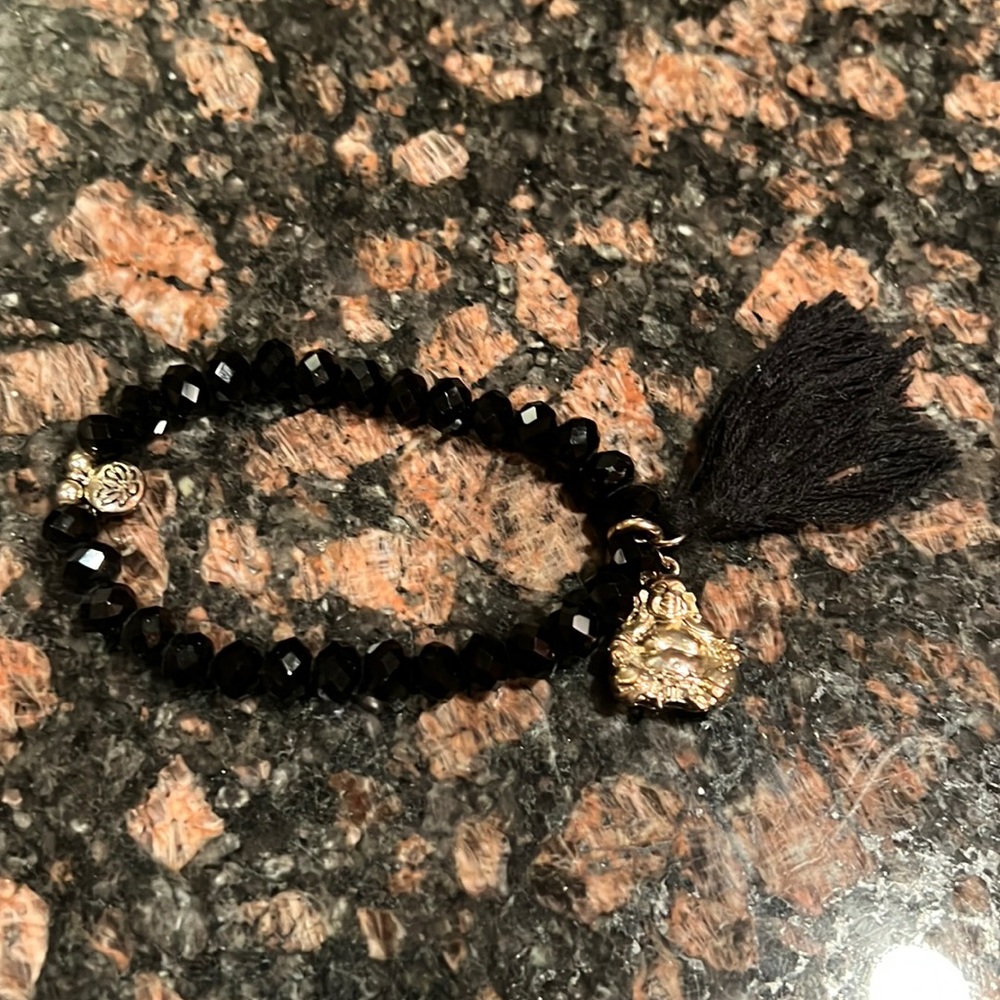 Stretchy beaded Buddha bracelet with OM charm and black tassel.